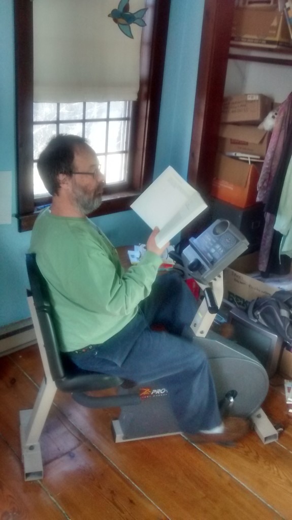 Shel reading at the exercise bike. Photo by D. Dina Friedman