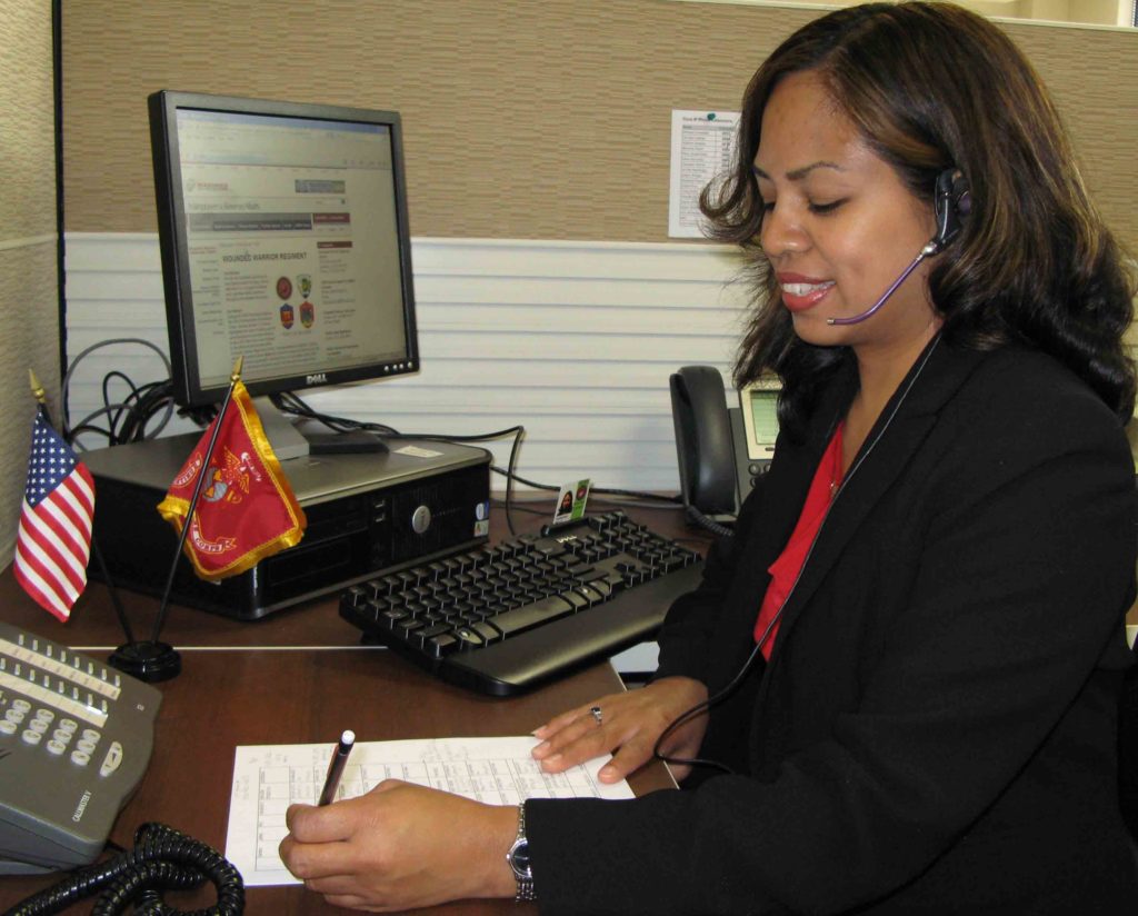 A woman on a customer service call, taking handwritten notes 